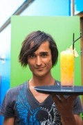 Beach cafe 'Rapa Nui'. Handsome waiter serving a cool drink at a beach pavilion.