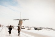 Boy and girl cycling home in a winter landscape.